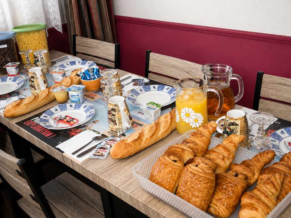 Table de petit-déjeuner continental avec baguette, croissants et café