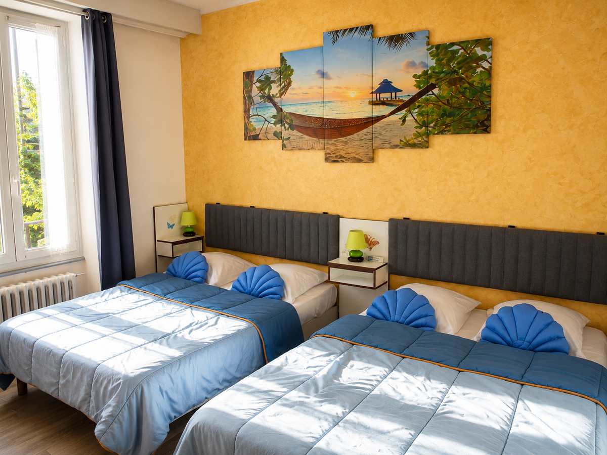 Chambre quadruple avec deux grands lits et la lumière du matin